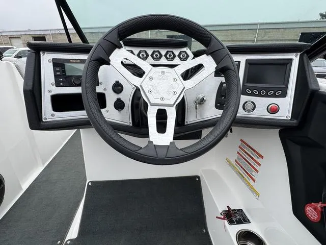 Slide: The Image of 2019 MasterCraft NXT22 boat interior with white captain's seat and steering wheel. - 19