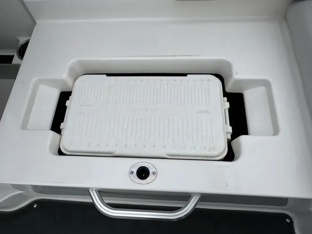 Slide: The Image of 2019 MasterCraft NXT22 storage compartment with black mat and cup holder. - 21