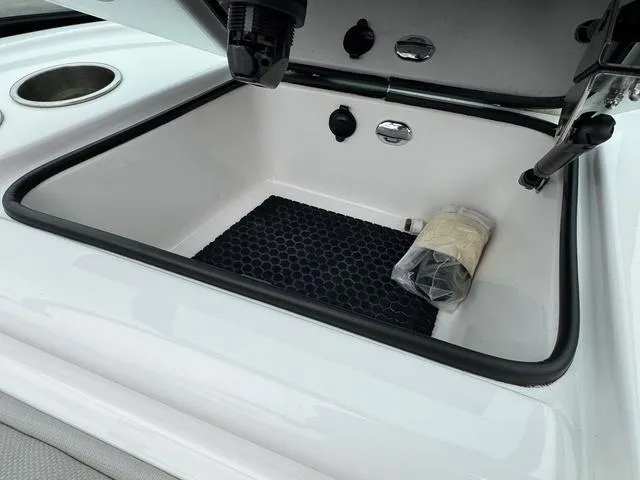 Slide: The Image of 2019 MasterCraft NXT22 storage area with fire extinguisher and carpeted interior. - 22