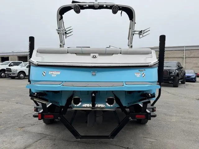 Slide: The Image of 2019 MasterCraft NXT22 boat, rear view, blue and white, parked outdoors. - 4