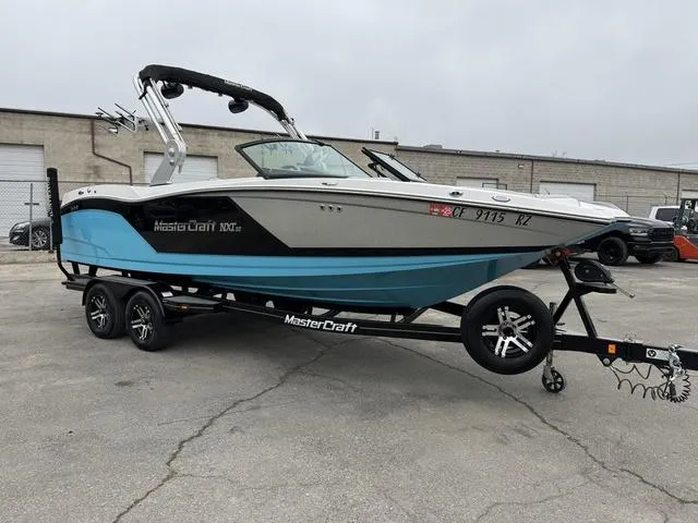 Slide: The Image of 2019 MasterCraft NXT22 boat on trailer, parked outdoors. - 6