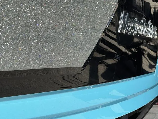 Slide: The Image of 2019 MasterCraft NXT22 boat, white and blue, parked outdoors. - 7