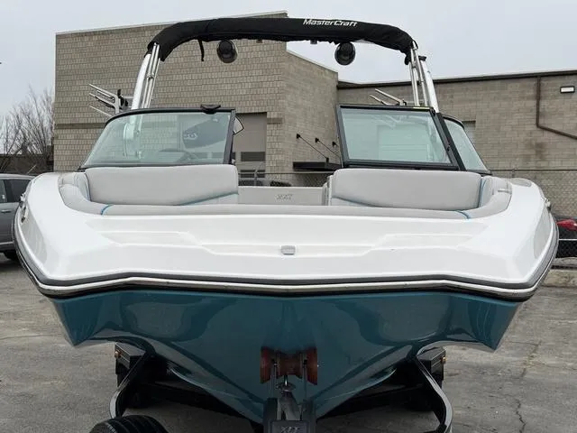Slide: The Image of 2019 MasterCraft NXT22 trailer wheels with black and silver rims on pavement. - 8