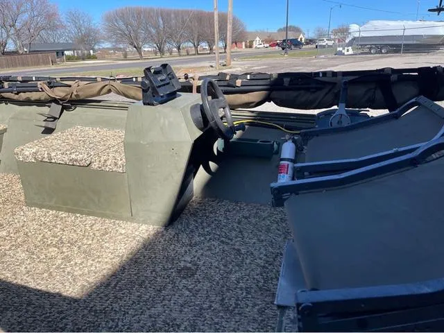 Slide: The Image of 2003 Lowe Roughneck boat interior with steering wheel and seating, parked outdoors. - 6