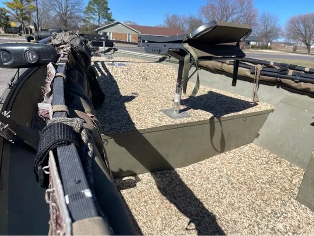 Slide: The Image of 2003 Lowe Roughneck boat interior with fishing gear and camouflage setup. - 7
