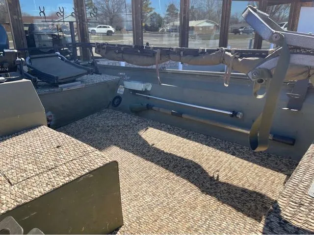 Slide: The Image of 2003 Lowe Roughneck boat interior with fishing rod holders and textured flooring. - 9