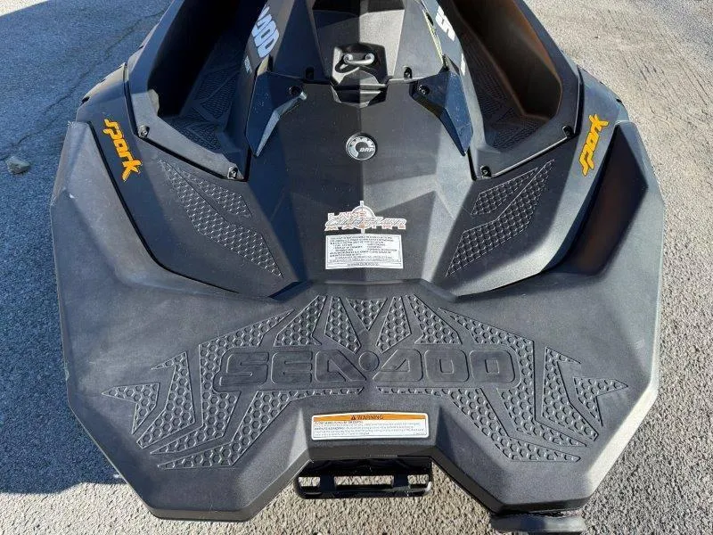 Slide: The Image of 2018 Sea-Doo Spark 3up jet ski, black with textured design, parked on pavement. - 22
