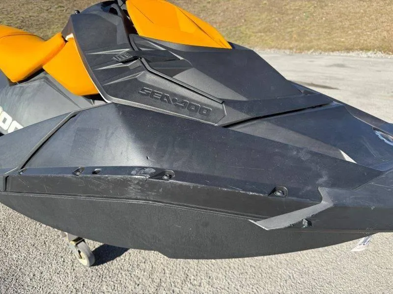 Slide: The Image of 2018 Sea-Doo Spark 3up jet ski, black and orange, parked on pavement. - 3