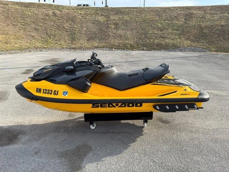 Slide: The Image of 2022 Sea-Doo RXP-X 300 jet ski, yellow and black, parked on pavement. - 10