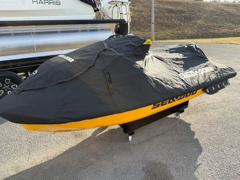 Slide: The Image of 2022 Sea-Doo RXP-X 300 covered, parked on pavement near a boat. - 19