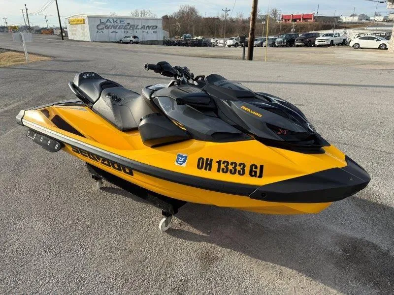 Slide: The Image of 2022 Sea-Doo RXP-X 300 jet ski in yellow and black, parked on pavement. - 3