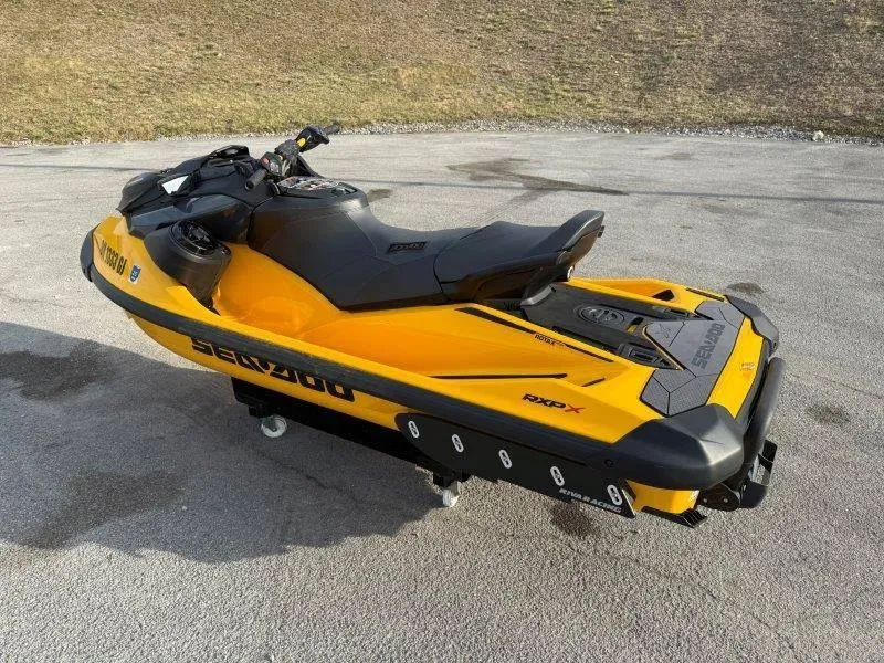 Slide: The Image of 2022 Sea-Doo RXP-X 300 jet ski, yellow and black, parked on pavement. - 9