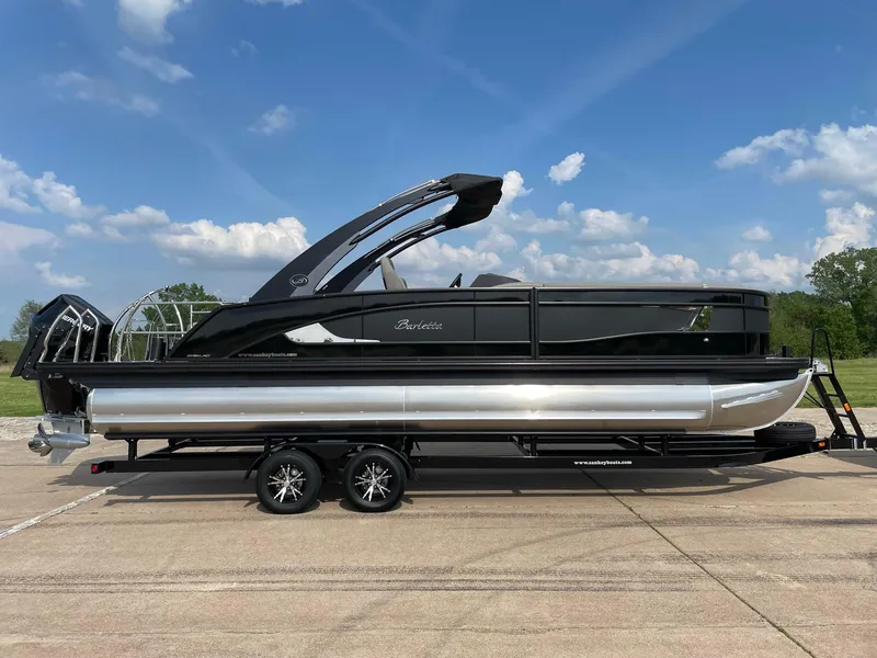Slide: The Image of 2023 Barletta Lusso 25UCA pontoon boat on trailer, under a clear blue sky. - 14