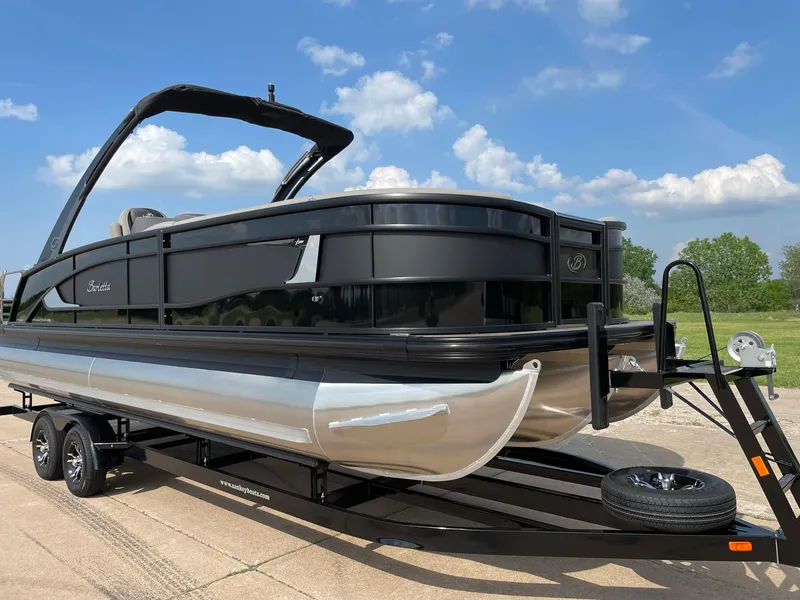 Slide: The Image of 2023 Barletta Lusso 25UCA pontoon boat on trailer, under a clear blue sky. - 16