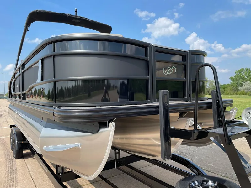 Slide: The Image of 2023 Barletta Lusso 25UCA pontoon boat on trailer, sleek design, sunny day. - 17