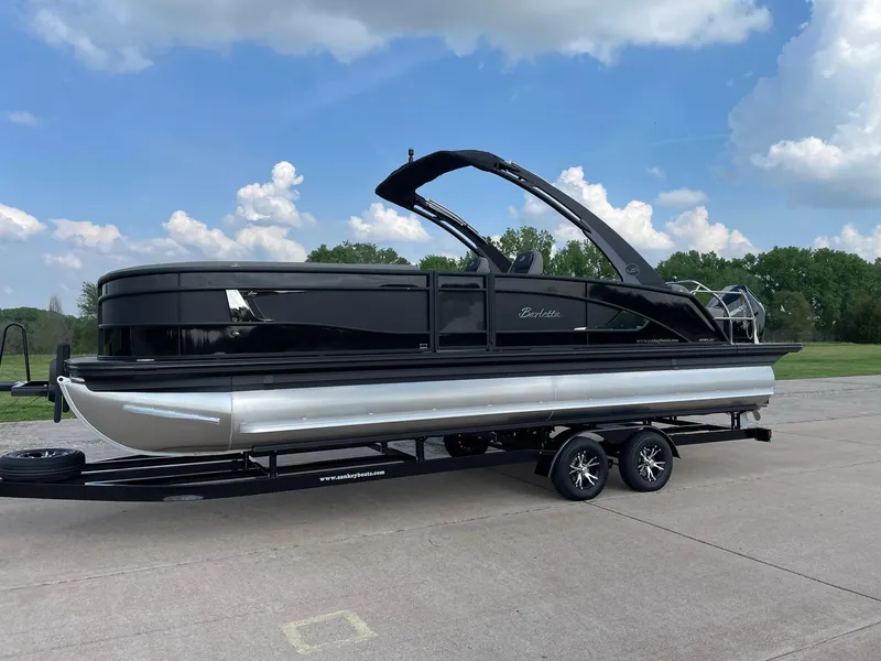Slide: The Image of 2023 Barletta Lusso 25UCA pontoon boat on trailer, under a blue sky. - 3
