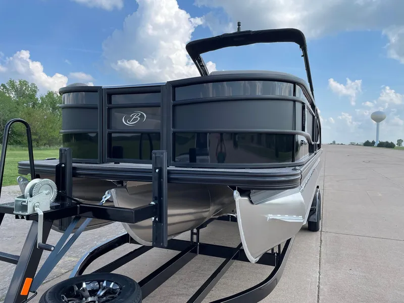 Slide: The Image of 2023 Barletta Lusso 25UCA pontoon boat on trailer, parked on a sunny day. - 6