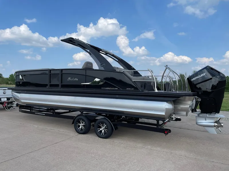 Slide: The Image of 2023 Barletta Lusso 25UCA pontoon boat on trailer, sleek black design, outdoor setting. - 7