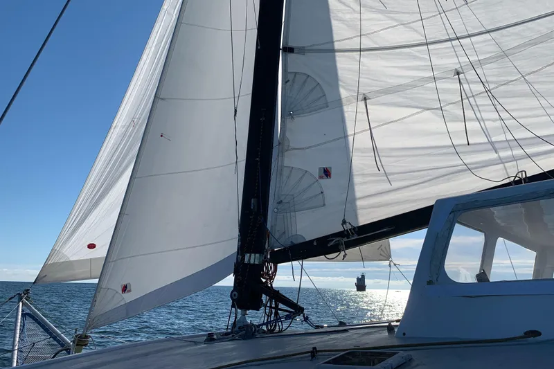 Slide: The Image of Sailing on a 1991 Crowther Custom 46 catamaran with white sails against a clear blue sky. - 11