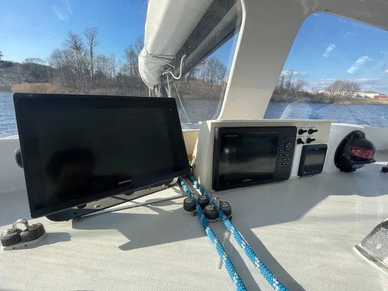 Slide: The Image of Cockpit of 1991 Crowther Custom 46 with navigation screens and ropes, overlooking a serene waterway. - 15