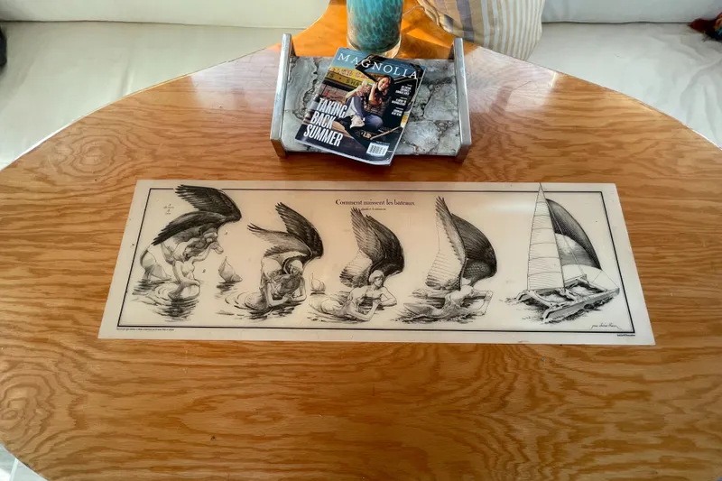 Slide: The Image of Wooden table with nautical artwork and magazines on a Crowther Custom 46, 1991 model. - 32
