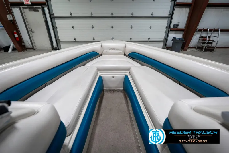 Slide: The Image of 1995 Crownline 182 BR boat interior with white and blue seating in a garage. - 18