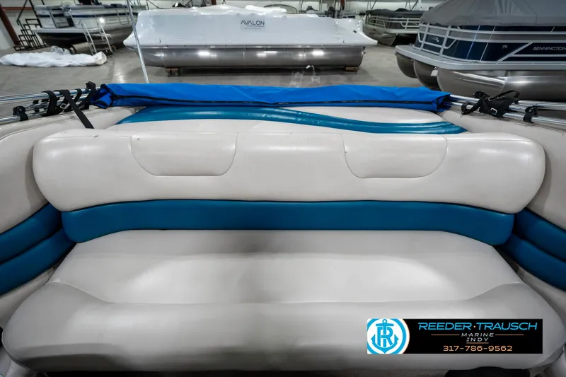 Slide: The Image of 1995 Crownline 182 BR boat interior with blue and white seating in showroom. - 21