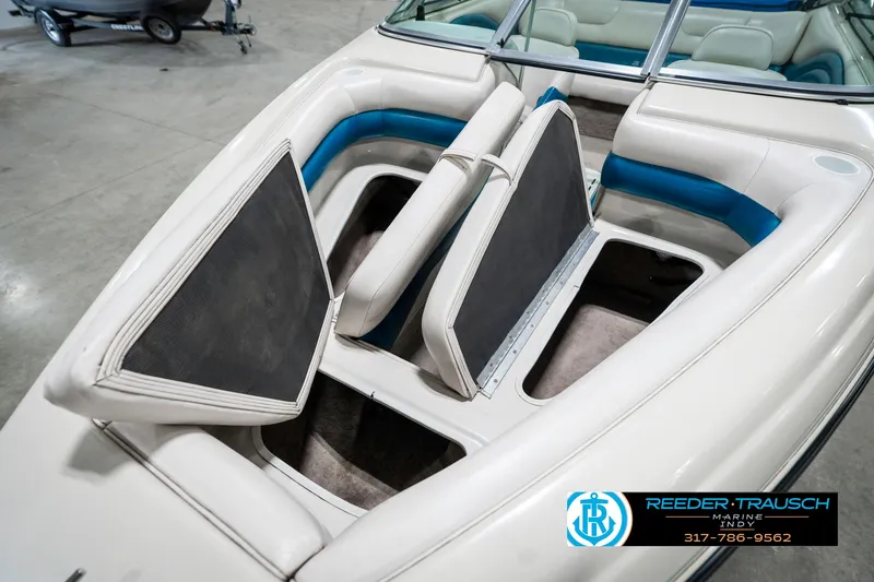 Slide: The Image of 1995 Crownline 182 BR boat interior with open storage compartments and blue accents. - 23