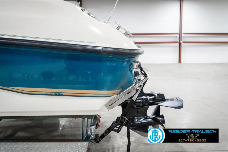 Slide: The Image of 1995 Crownline 182 BR boat in a garage, featuring a blue and white hull. - 46