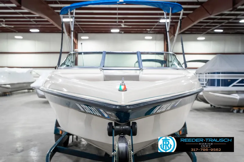 Slide: The Image of 1995 Crownline 182 BR boat with blue canopy in indoor storage facility. - 5