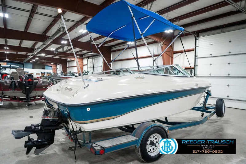 Slide: The Image of 1995 Crownline 182 BR boat with blue canopy on trailer in indoor showroom. - 8