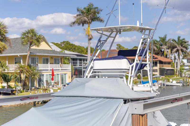 Slide: The Image of 2023 Edgewater 370CC boat docked near waterfront homes with palm trees. - 10