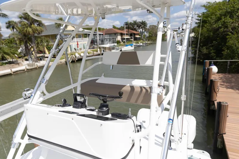 Slide: The Image of 2023 Edgewater 370CC boat helm with controls, docked by a canal. - 12