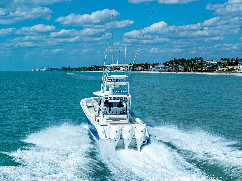 Slide: The Image of Edgewater 370CC 2023 boat cruising on blue ocean under a partly cloudy sky. - 35