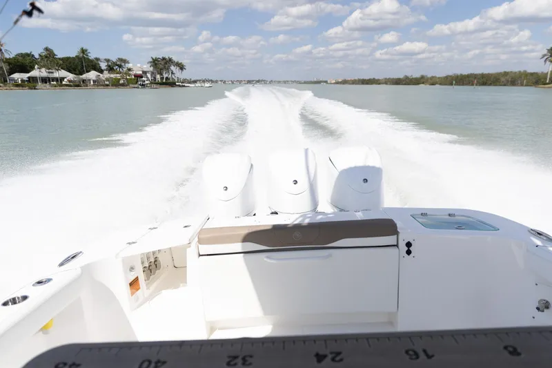 Slide: The Image of 2023 Edgewater 370CC boat speeding on a sunny day, leaving a wake trail. - 42