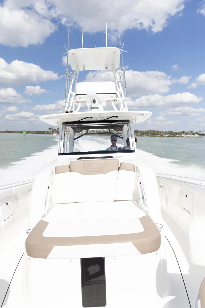 Slide: The Image of 2023 Edgewater 370CC boat cruising on a sunny day with blue skies and clouds. - 43