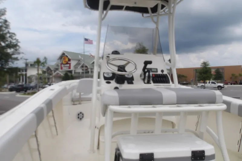 Slide: The Image of 2025 Mako 214 Center Console boat with steering wheel and controls, parked outdoors. - 13