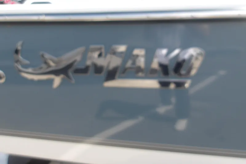 Slide: The Image of 2025 Mako 214 Center Console boat logo on sleek blue hull. - 23
