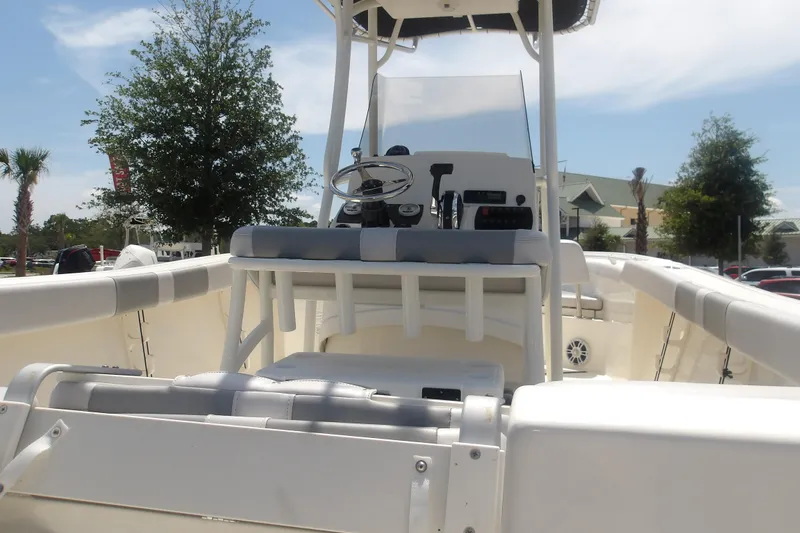 Slide: The Image of 2025 Mako 214 Center Console boat interior with steering wheel and seating, under clear sky. - 6