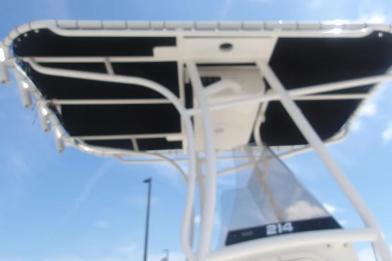 Slide: The Image of 2025 Mako 214 Center Console boat with T-top against blue sky. - 22