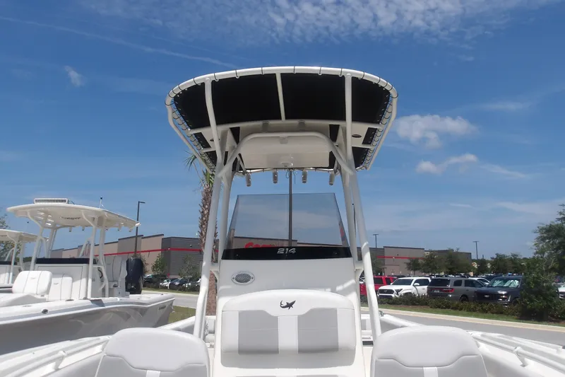 Slide: The Image of 2025 Mako 214 Center Console boat displayed outdoors under a clear blue sky. - 13