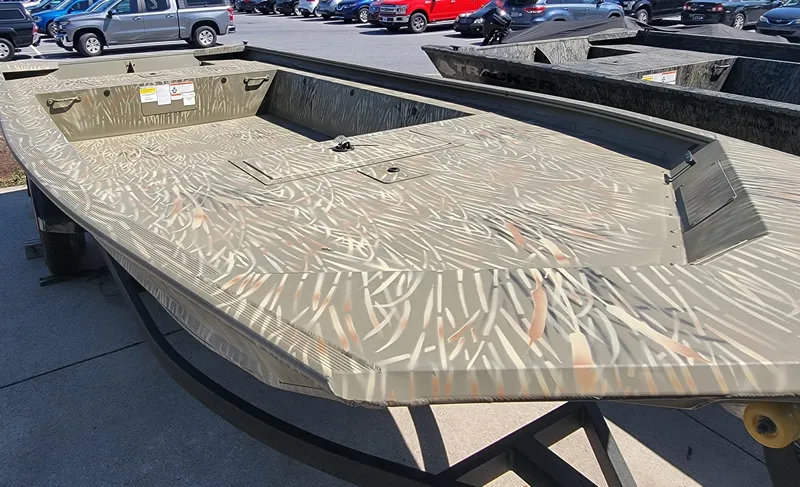 Slide: The Image of 2025 Tracker Grizzly 1754 Jon boat with camouflage pattern, parked outdoors. - 2