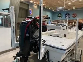 Slide: The Image of 2025 Mako 18 LTS boat displayed indoors with motor and fishing equipment. - 2