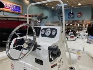 Slide: The Image of 2025 Mako 18 LTS boat dashboard with steering wheel and gauges in showroom. - 3