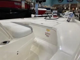 Slide: The Image of 2025 Mako 18 LTS boat interior, showcasing seating and deck features in showroom. - 4