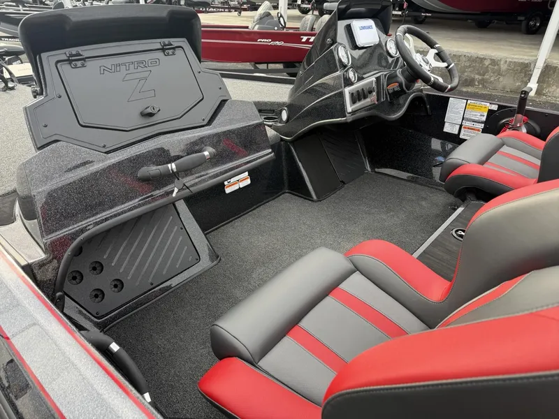 Slide: The Image of 2025 Nitro Z19 boat interior with red and gray seating, steering console, and storage compartments. - 5