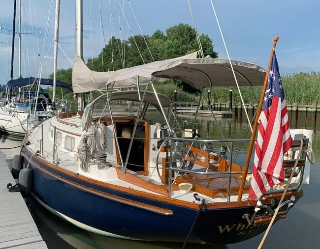 The Image of 1981 Bristol 40 sloop docked, featuring classic design and American flag. - 0