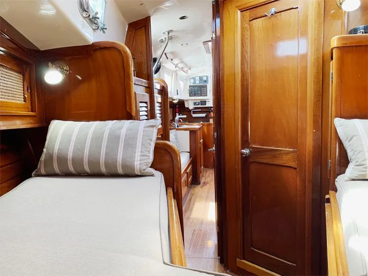 Slide: The Image of Interior of 1981 Bristol 40 Sloop, featuring wooden cabinetry and cozy sleeping quarters. - 10