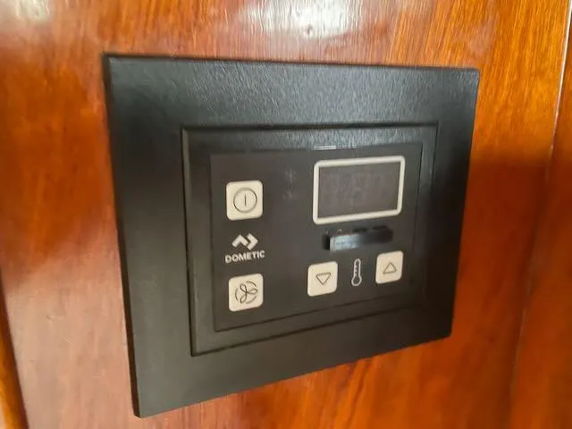 Slide: The Image of Control panel on 1981 Bristol 40 Sloop, featuring Dometic interface on wooden surface. - 23