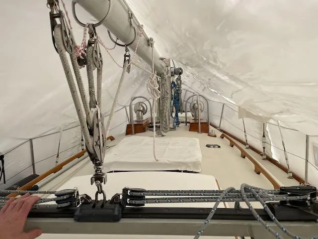 Slide: The Image of 1981 Bristol 40 Sloop deck under cover, showcasing rigging and mast details. - 32